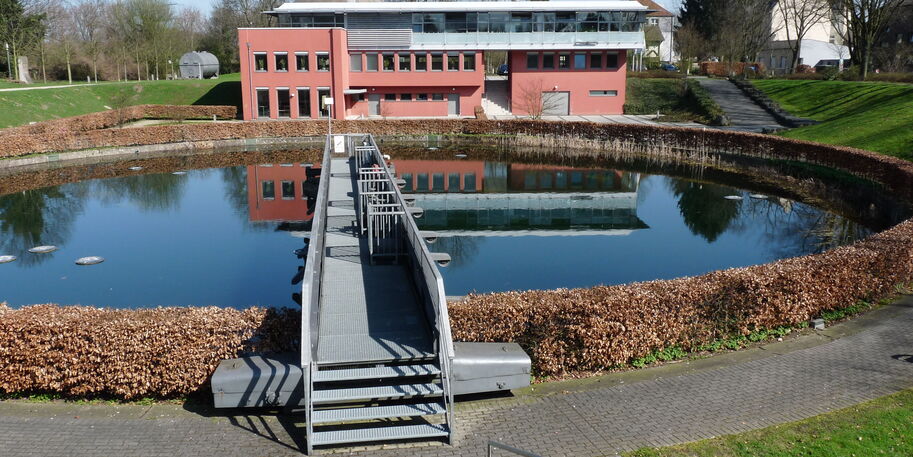 Ein kreisförmiges Klärbecken mit einer Brücke oben drüber.